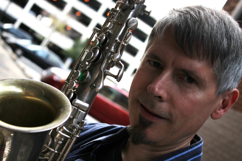 A color photo pf Frank Trompeter close-up next to saxophone