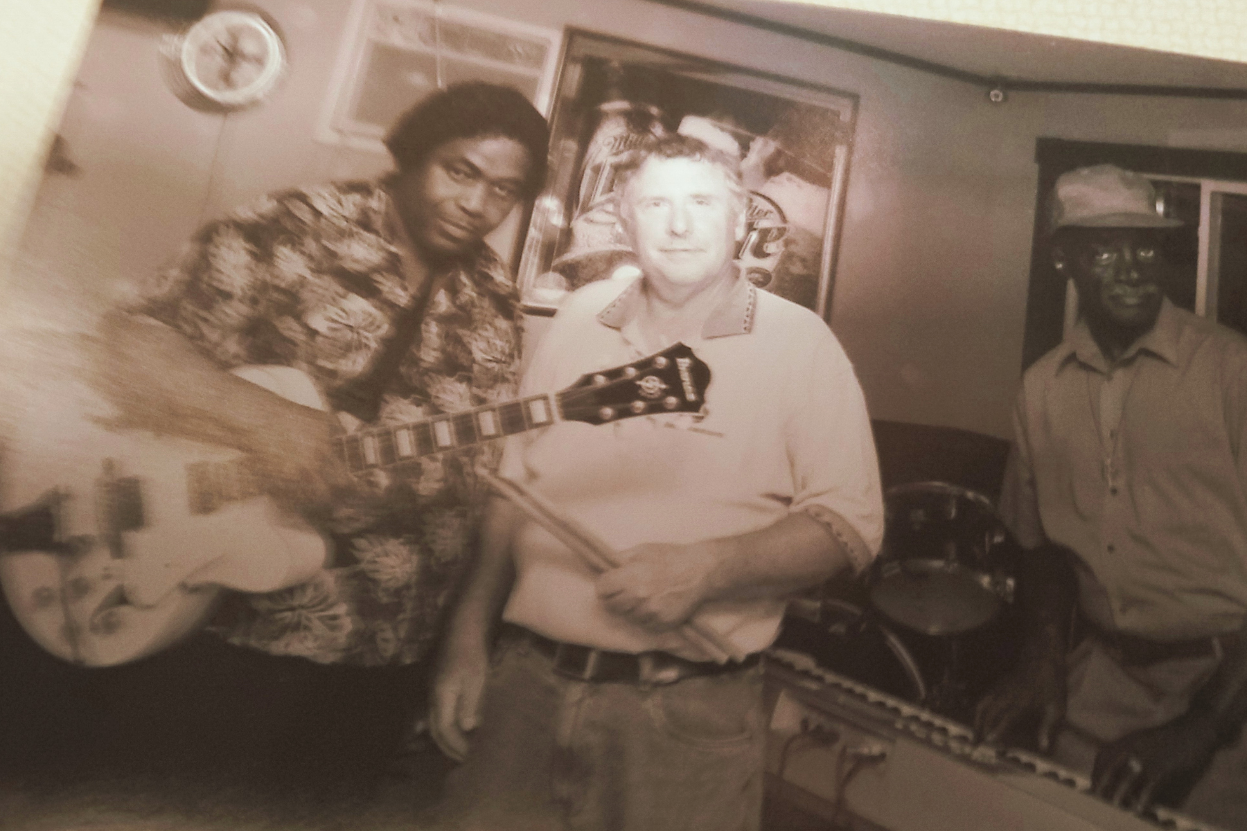 Sepia toned photo of Stone Cold Blues Band members posing with a guitar