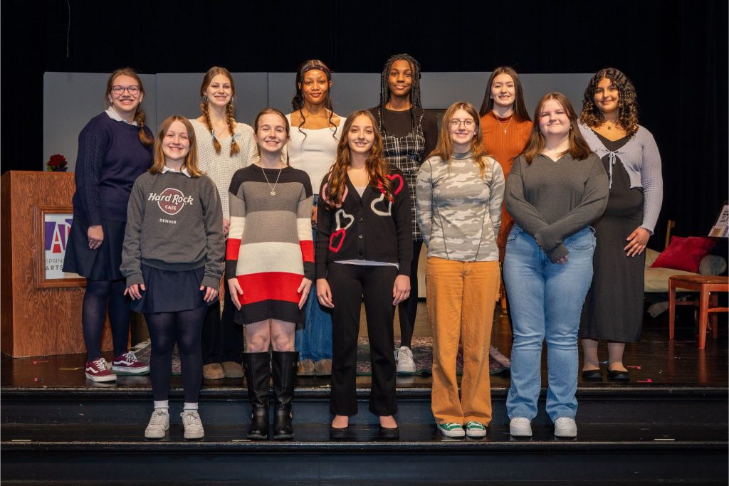 A color photo of 11 girls standing on a stage looking into the camera. Front row, left to right: Avery Arisman, Morgan Hoekstra, Aryana Ruiz, Emma Selhime, Ella Meyer Back row, left to right: Anna Reeder, Kallie Padget, Ashyla Richards, Nadia Currie, Marianna Curtis, Jillian Garcia