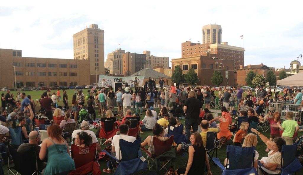 image of a crowd sitting on the grass in downtown springfield waiting for a concert to begin.