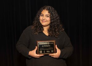 young woman smiling holding an award