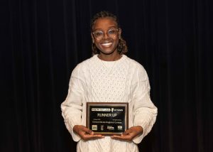 young woman smiling holding an award