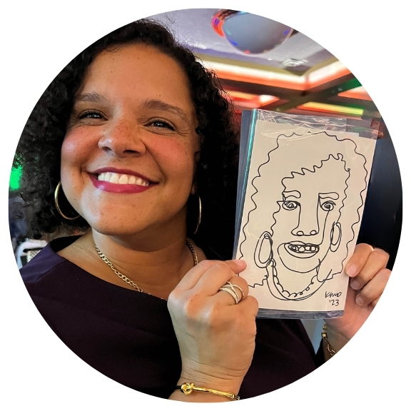 Woman smiling, holding up a caricature portrait.