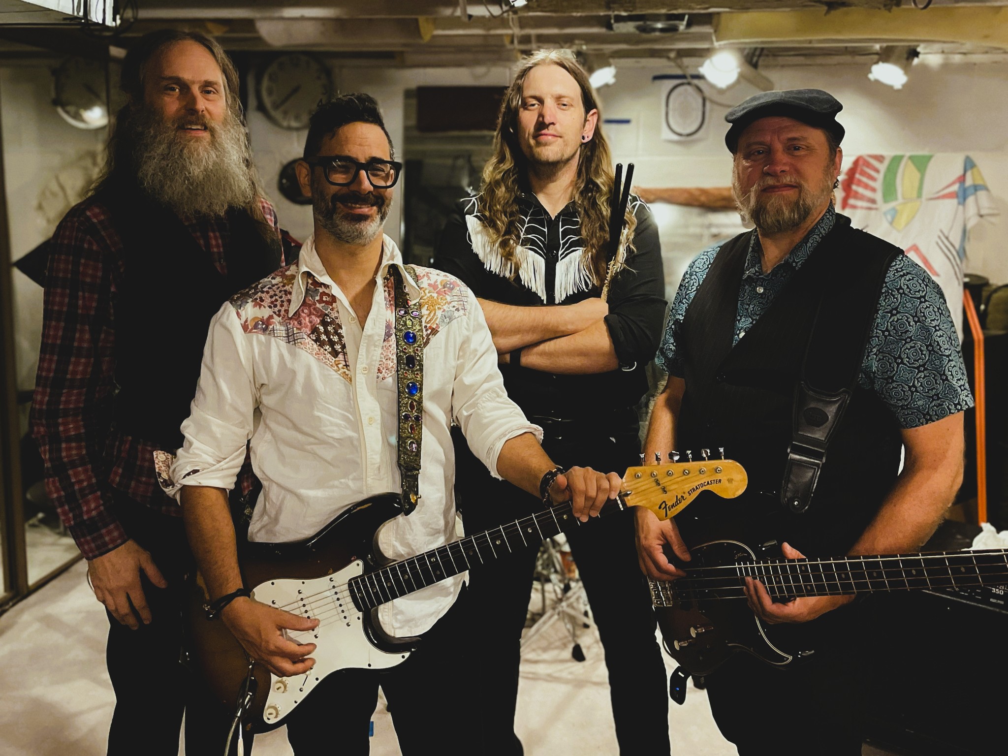 Band of four musicians posing with guitar