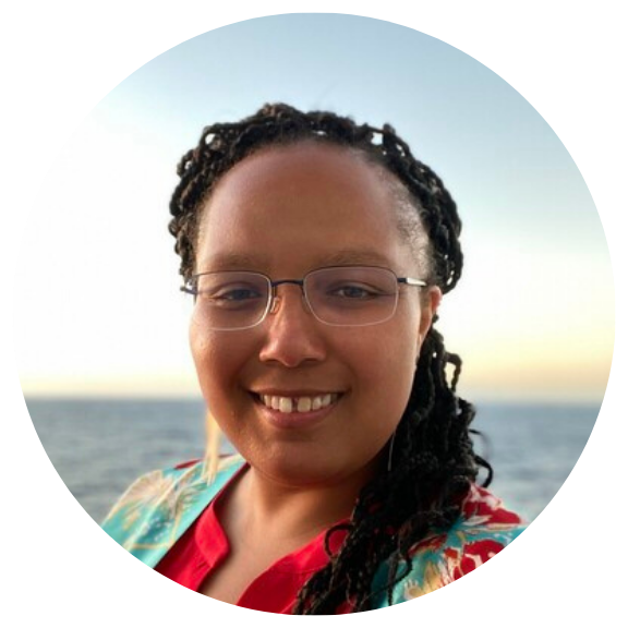 Black woman smiling at camera on a beach