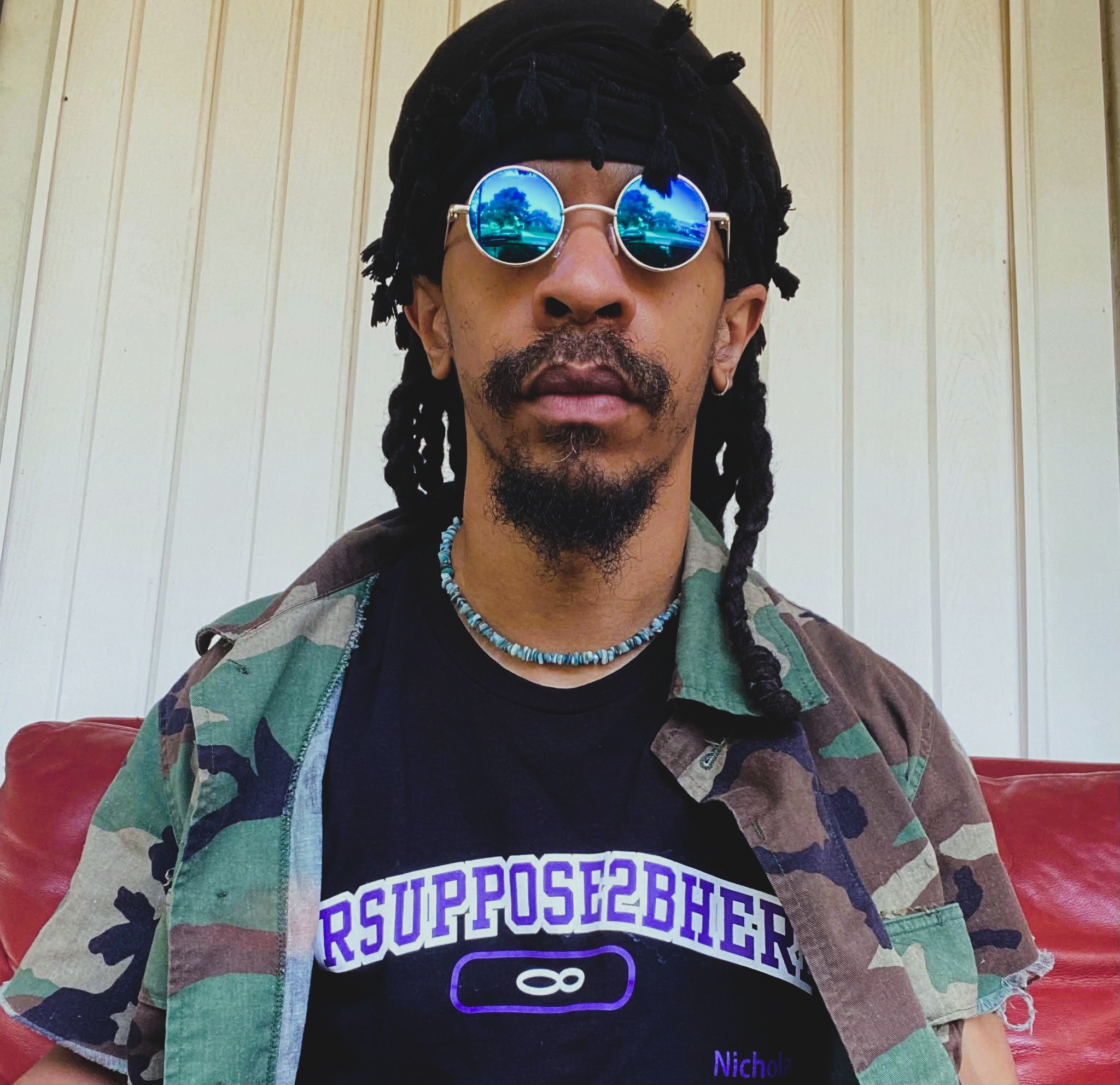 Man wearing sunglasses with a neutral expression staring at camera