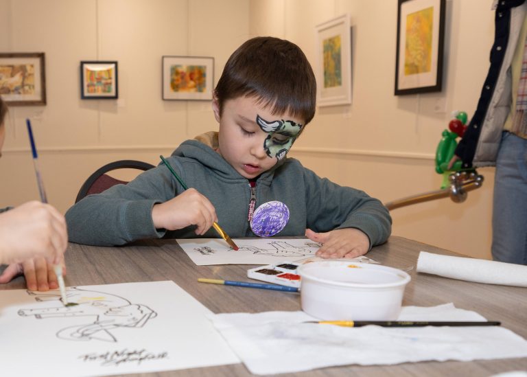 Young boy painting with a group